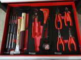 de nombreux outils divers dans une boîte rouge posée par terre