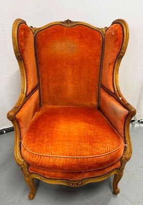 an orange chair in a room with a white wall behind it