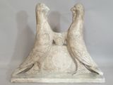 une paire d'oiseaux en marbre blanc posés sur un socle en pierre