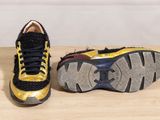 pair of yellow and black sneakers on a wooden surface