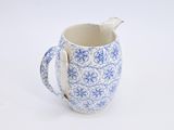 a blue and white pitcher with a spoon in it