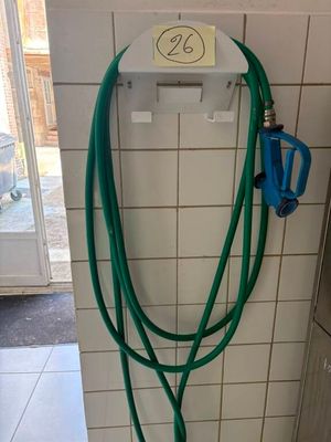 un tuyau vert fixé au mur d'une salle de bains