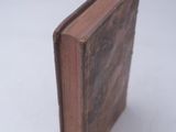 an old book sitting on top of a table covered in snow