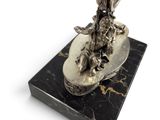 a silver figurine of a man on a horse on a marble base