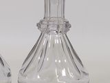 two clear glass vases sitting next to each other on a table