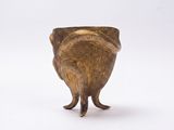 un petit vase en bronze sur lequel est représenté un oiseau debout