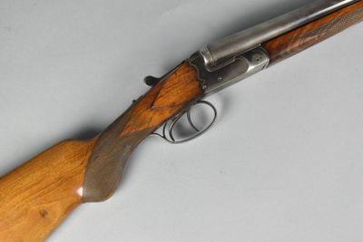 a close up of a rifle with a wooden handle on a table