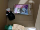 a cardboard box with a bag of toilet paper and a toilet brush