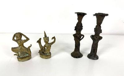 three bronze figurines sitting on a white surface with a white background