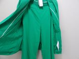 green jacket and pants hanging on a hanger in front of a white wall