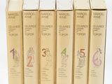 cinq livres alignés sur une surface blanche, sur fond blanc