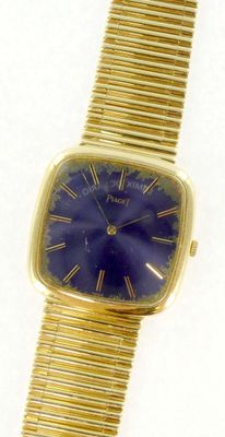 un gros plan d'une montre-bracelet en or avec un cadran bleu