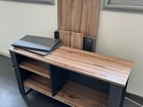 un bureau en bois sur lequel est posé un ordinateur portable, dans une pièce