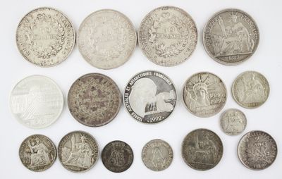 an assortment of silver and silver coins on a white surface