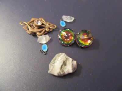 une pierre, un collier et une paire de boucles d'oreilles posés sur une table