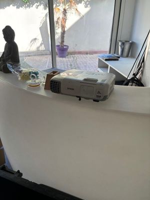 un homme assis à un bureau sur lequel se trouve un projecteur