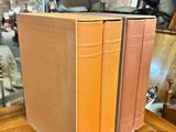 three books that are sitting on a wooden table