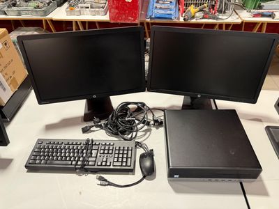 two computer monitors and a keyboard on a desk