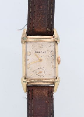 une photo d'une montre-bracelet plaquée or avec un bracelet en cuir marron