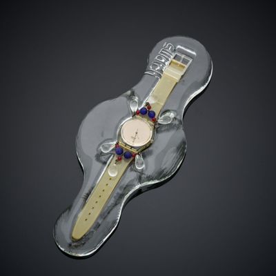 a watch sitting on top of a clear piece of plastic
