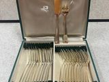 un coffret vert contenant de l'argenterie sur une table