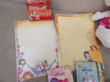 a teddy bear sitting on a couch next to a notepad and other items