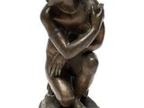 bronze figurine of a young boy sitting on a pedestal