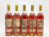 quatre bouteilles de vin sont alignées sur une surface blanche