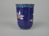 a blue vase with flowers on it sitting on a table