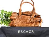 brown leather handbag with a black bag and a plant in it