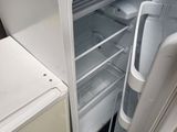 an open refrigerator with a microwave on top of it