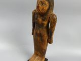 an old wooden statue of a woman standing on a wooden base