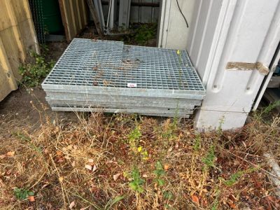 une grille métallique posée au sol à côté d'un bâtiment