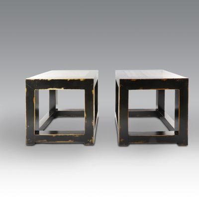 a pair of black and gold side tables