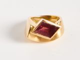 an image of a gold ring with a red stone in the center