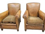 deux fauteuils en cuir marron, ornés de coussins, sur fond blanc