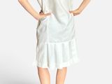 the woman is wearing a white dress and black shoes