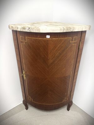 a marble top corner cabinet in the corner of a room