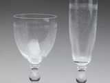 two empty wine glasses sitting next to each other on a table