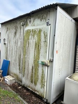 une photo d'un petit bâtiment de stockage muni d'une porte