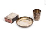 une assiette en argent et une tasse en argent posées sur un fond blanc