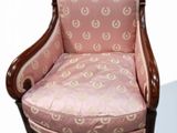 a pink chair that is sitting on a white surface