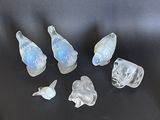 cinq oiseaux en verre posés sur une surface noire