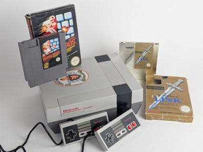 a nintendo game system sitting on top of a table next to a box of nintendo games