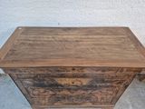 an image of a wooden chest sitting on top of a cement floor