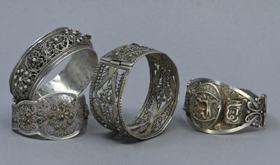 three silver rings and a silver ring with a cross on it
