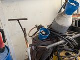 un seau bleu posé sur une table, à côté d'une pile d'outils