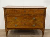 une commode ancienne en bois posée sur un sol carrelé