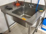 a stainless steel sink in the corner of a kitchen