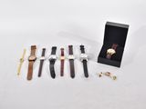trois montres et une bague en or sont posées sur une table